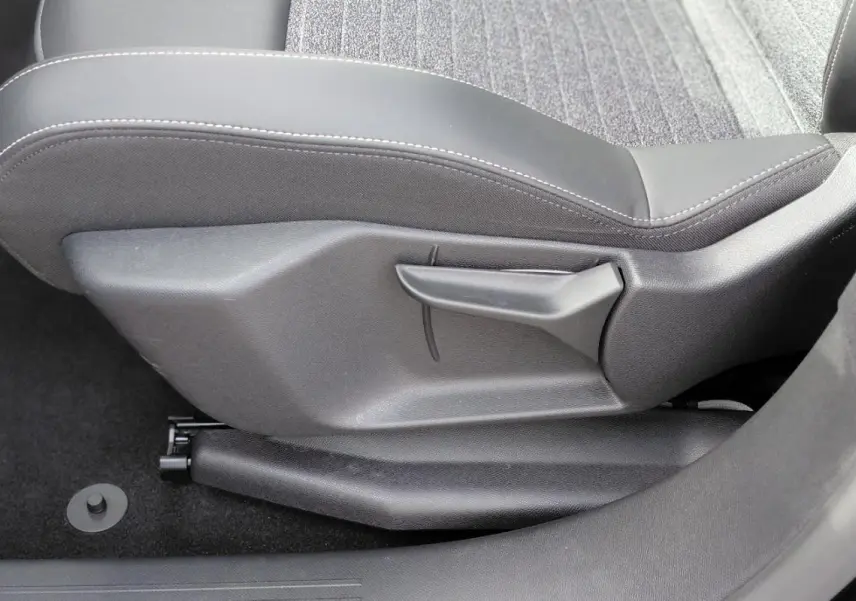 Détail de la commande de réglage manuel du siège avant droit du Peugeot 3008 Hybrid 136 e-DCS6 Allure noir 2025.