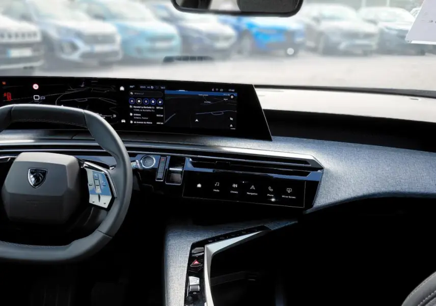 Vue intérieure frontale du cockpit numérique du Peugeot 3008 Hybrid 136 e-DCS6 Allure 2025 avec volant compact et écran large.