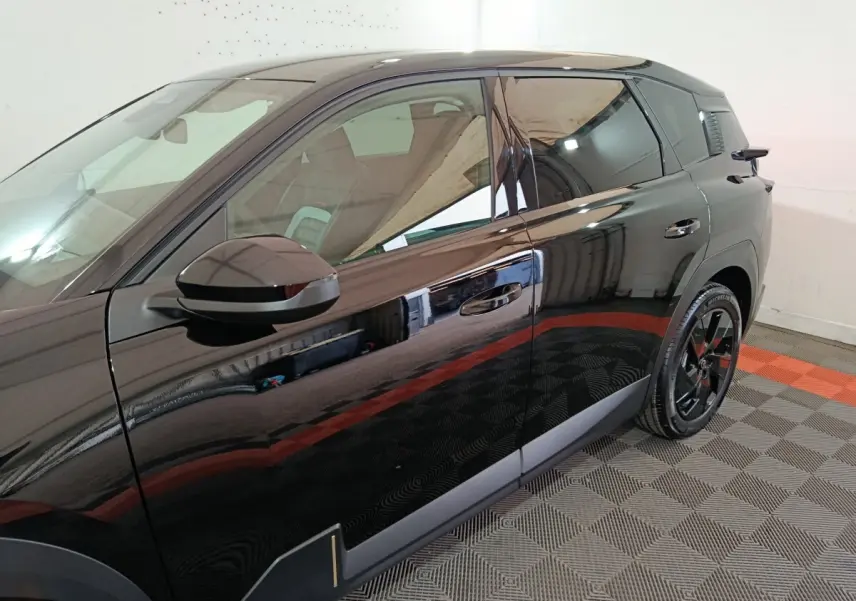 Vue latérale droite d'une Citroën C5 Hybride noire 2026 avec jantes noires et détails chromés sur porte.