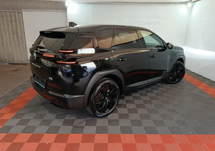 Vue 3/4 arrière droite d'une Citroën C5 noire avec feux arrière LED horizontaux et jantes noires brillantes.