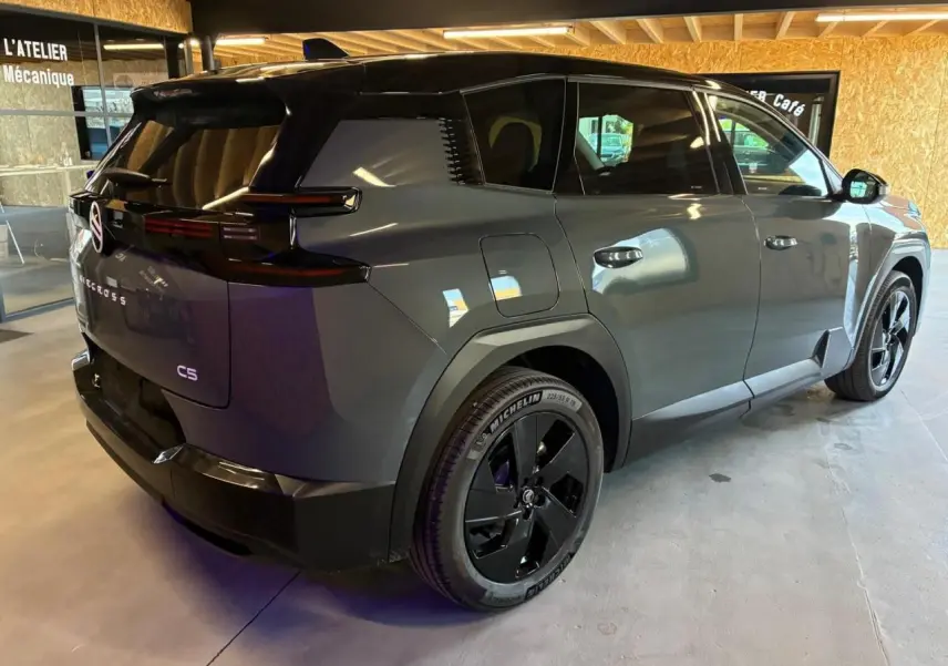 Vue 3/4 arrière droite du Citroën C5 Aircross 2026 vert, avec toit noir et jantes noires distinctives.