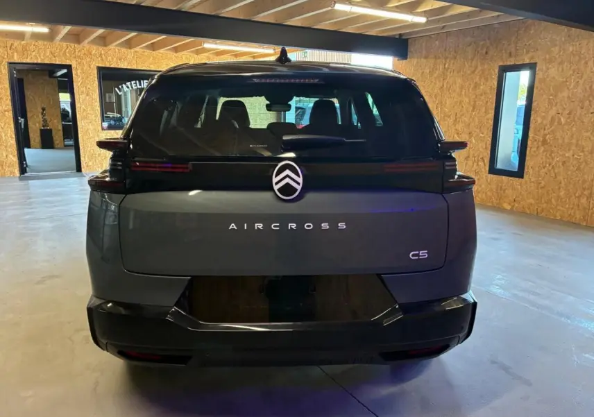 Vue arrière d'un Citroën C5 Aircross vert 2026 dans un garage, avec logo et nom du modèle bien visibles.