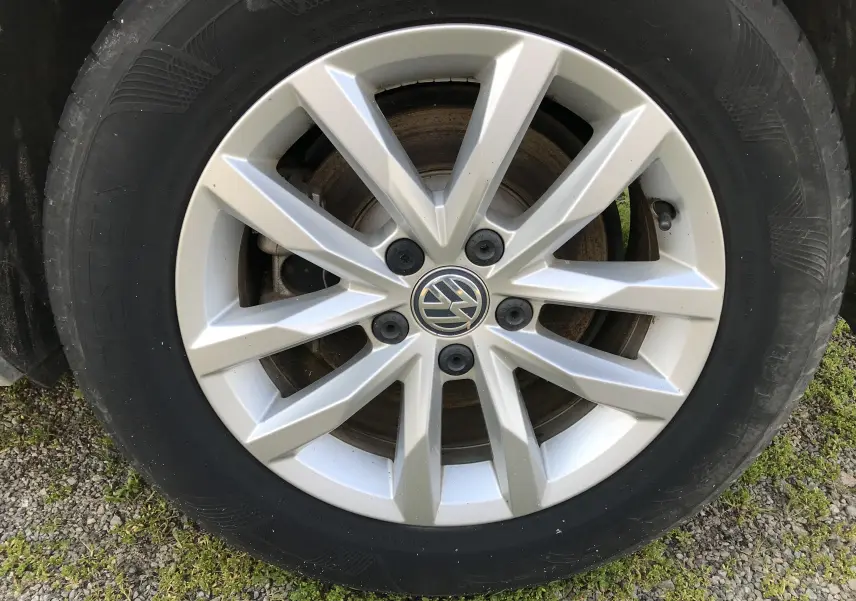 Gros plan sur la jante alliage argentée avec logo Volkswagen d'une Passat Confortline Business 2015.