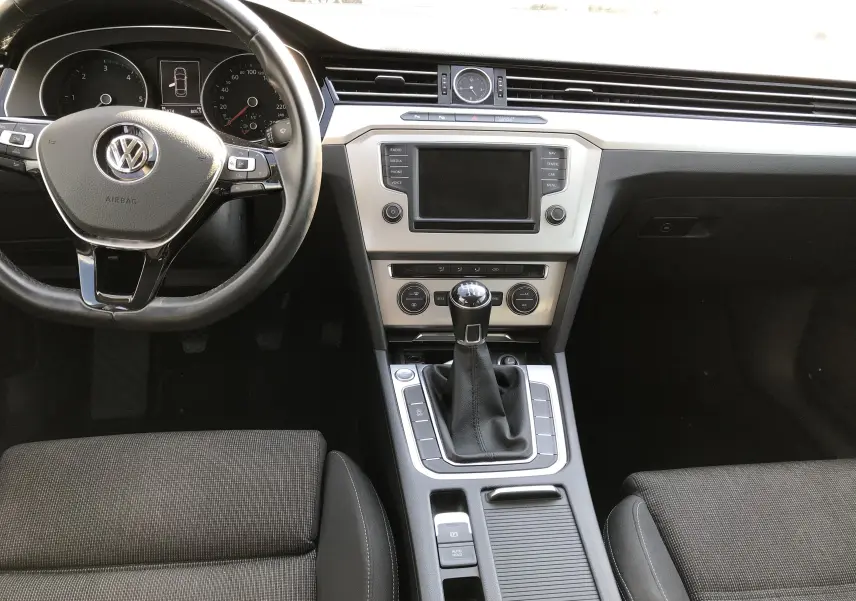 Intérieur de Volkswagen Passat confortline business 2015, vue centrale sur tableau de bord et levier de vitesse manuel.