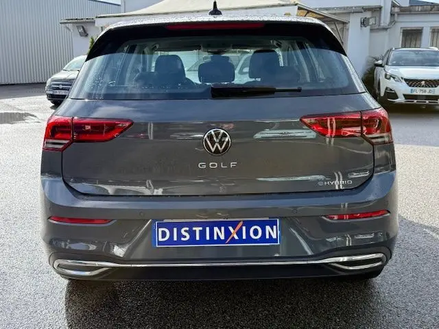 Vue arrière d'une Volkswagen Golf VIII gris dauphin avec badge Hybrid et feux LED distinctifs.