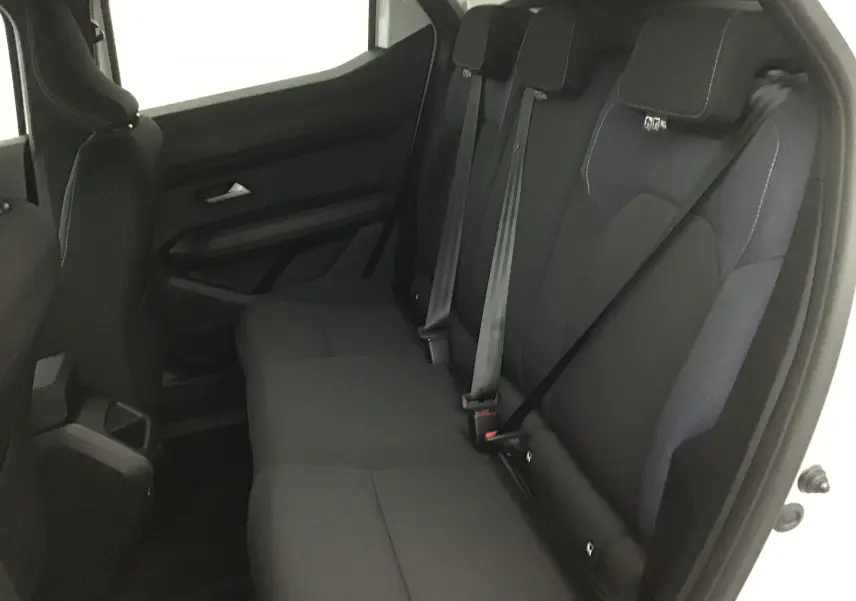 Vue intérieure du siège arrière droit du Dacia Duster blanc glacier 2025 avec ceintures de sécurité visibles.