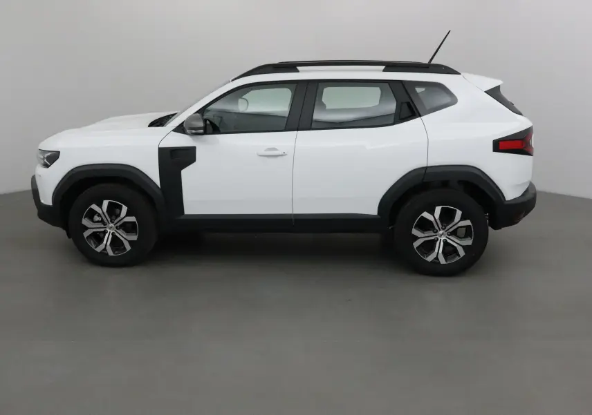 Profil droit du Dacia Duster blanc glacier 2025, avec protections noires et jantes alliage 17 pouces.