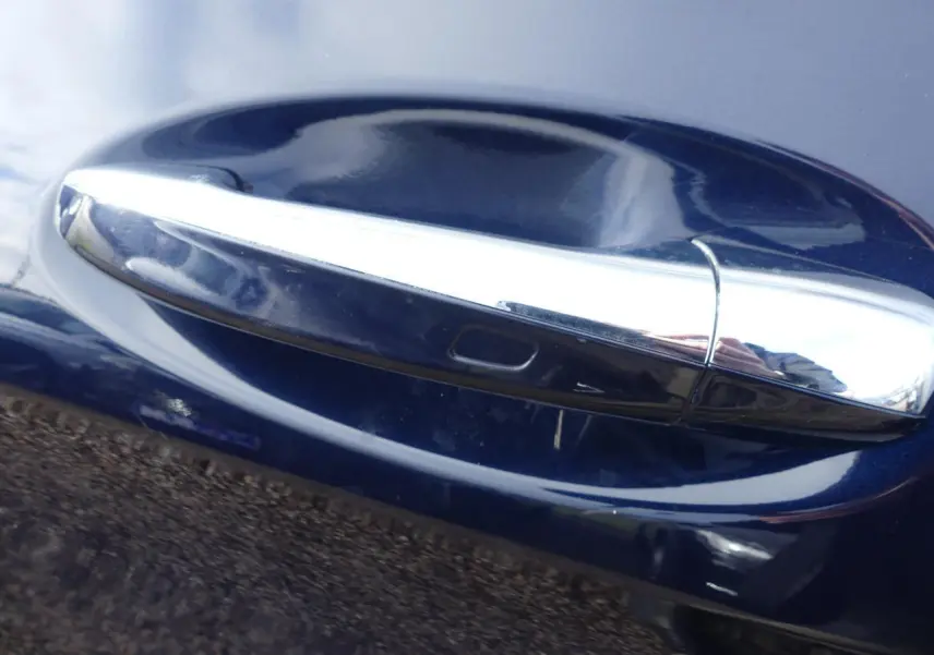Poignée de porte chromée sur la portière côté droit d'une Mercedes GLC Coupé 300 hybride bleu foncé.