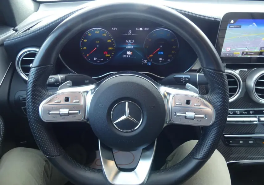Volant sport en cuir noir avec commandes intégrées et tableau de bord digital d'une Mercedes GLC Coupé 300 hybride.