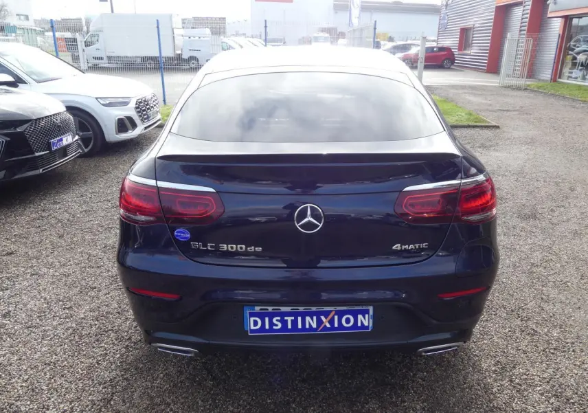 Vue arrière d'un Mercedes GLC 300 de hybride bleu foncé avec logo 4MATIC et doubles sorties d'échappement chromées.