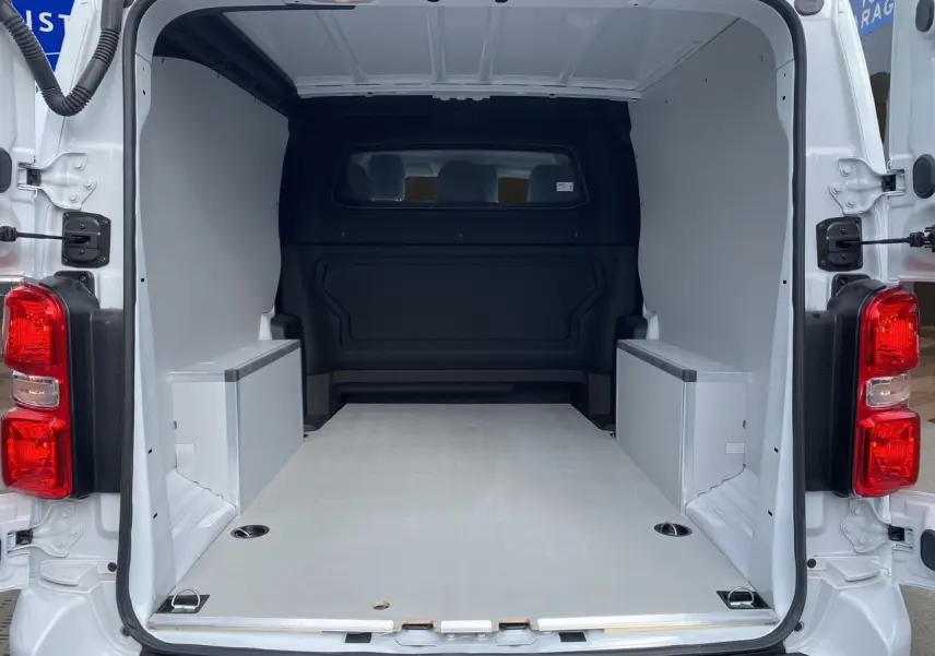 Intérieur arrière du fourgon blanc Opel Vivaro 2025, montrant la zone de chargement vide avec plancher bois antidérapant.