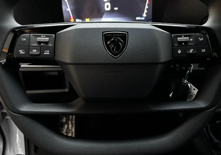 Gros plan sur le volant noir multifonctions avec logo Peugeot du Peugeot Expert Fourgon Taille M 2025.