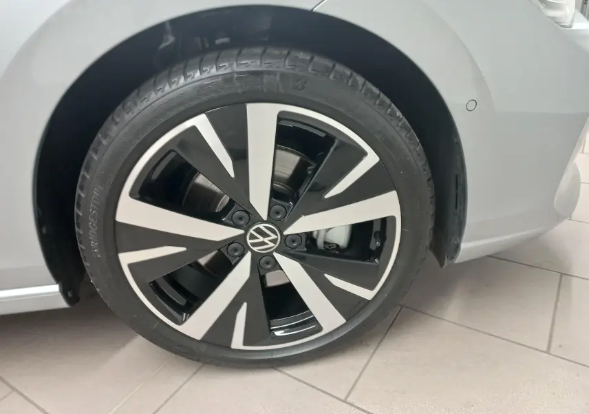 Gros plan sur la jante alliage 18'' Catania noire et argentée du côté avant droit d'une Volkswagen Golf 1.5 eHybrid argent Dolomite.