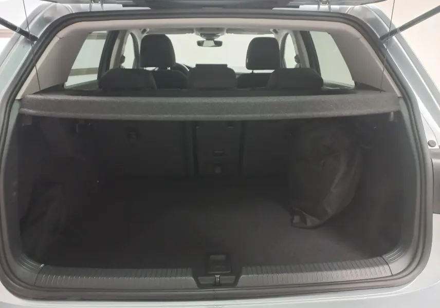 Vue arrière du coffre ouvert d'une Volkswagen Golf 1.5 eHybrid 204 DSG6 argent Dolomite, montrant l'espace de chargement et la plage arrière.