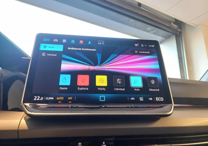 Écran tactile central de la Volkswagen Golf 1.5 eHybrid 2025 affichant les ambiances lumineuses, intérieur moderne et épuré.