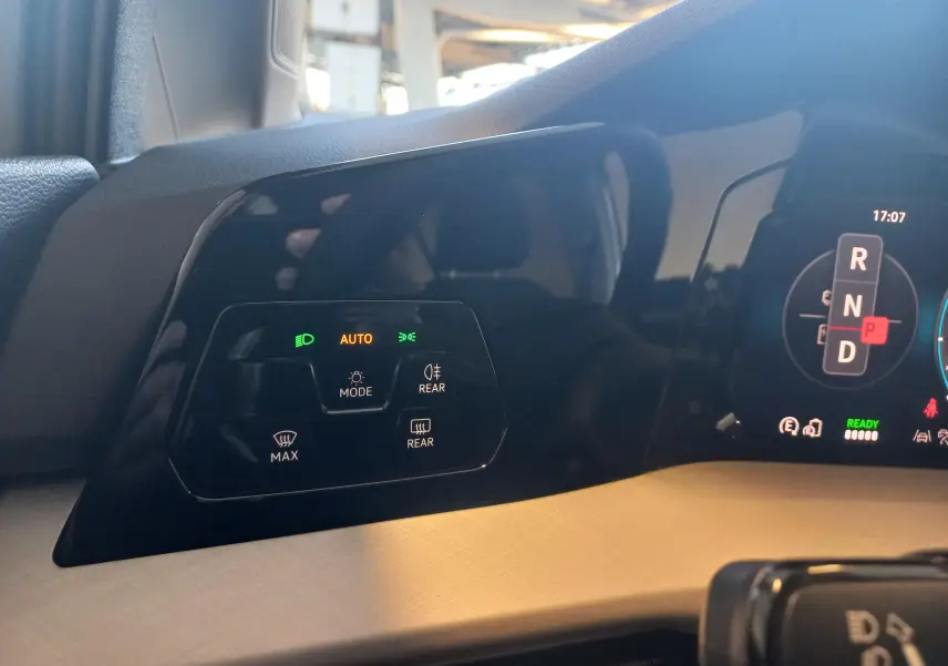 Détail du tableau de bord de la Volkswagen Golf 1.5 eHybrid 2025 montrant les commandes d'éclairage et l'affichage numérique.