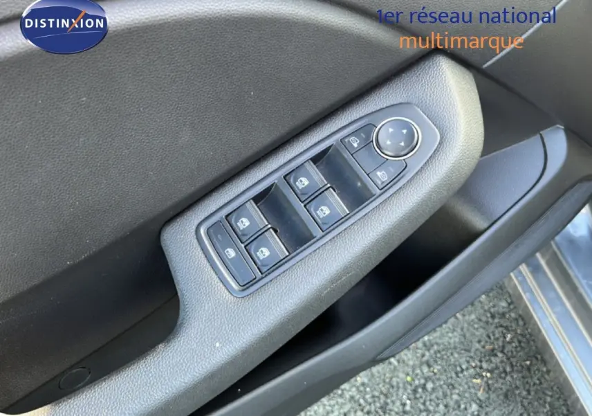 Gros plan sur la commande des vitres électriques côté conducteur de la Renault Clio gris schiste métal, porte ouverte.