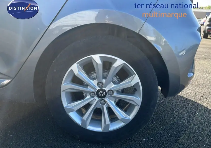 Gros plan sur la roue avant droite d’une Renault Clio gris schiste métal, mettant en valeur la jante alu moderne.