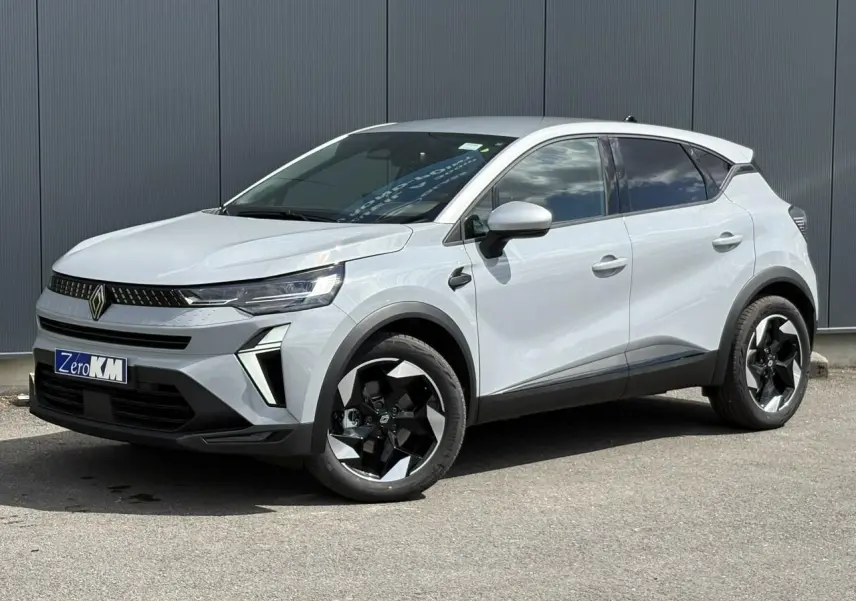Renault Captur 2025 gris Rafale en 3/4 avant droit avec jantes noires et toit gris Highland visible