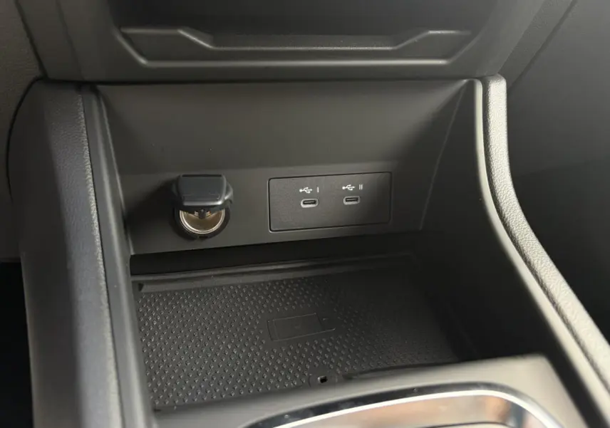 Gros plan sur la console centrale du Renault Captur 2025 avec ports USB-C et prise 12V, finition noire.