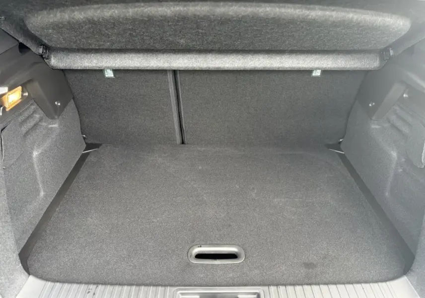 Coffre ouvert du Renault Captur Gris Rafale, vue intérieure arrière montrant le volume de chargement et la moquette grise.