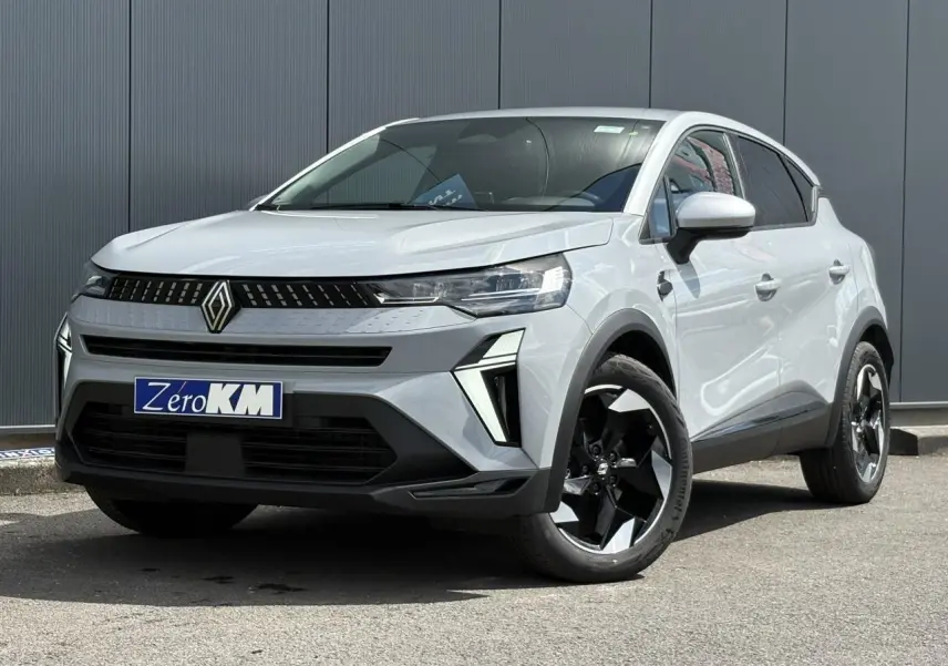 Renault Captur gris Rafale en 3/4 avant droit, avec jantes noires et calandre moderne au logo centré.