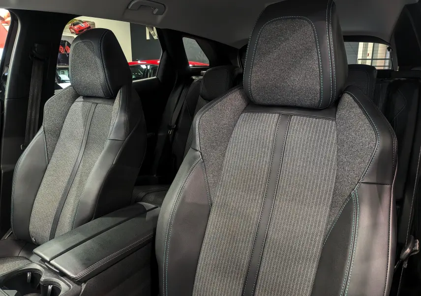 Gros plan sur les sièges avant en tissu gris et cuir noir avec surpiqûres bleues du Peugeot 3008 BlueHDi 130 Allure 2022.