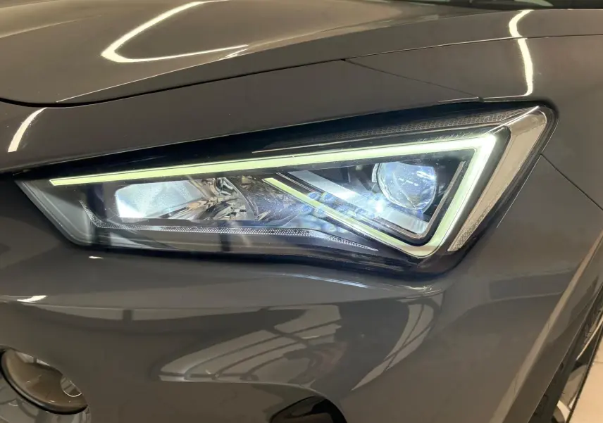 Gros plan sur le phare avant droit du CUPRA Formentor 1.5 TSI gris Graphène avec éclairage LED distinctif.