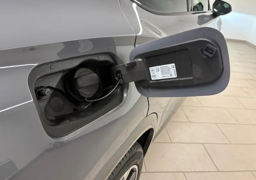 Gros plan sur la trappe à carburant ouverte côté gauche du CUPRA Formentor gris Graphène, montrant le bouchon essence.