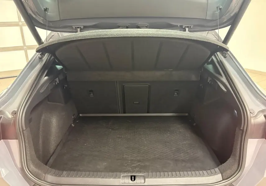 Coffre ouvert vu de l'arrière d'une CUPRA Formentor gris Graphène, montrant l'espace de chargement et la tablette arrière relevée.