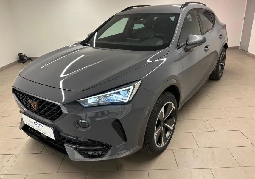 Vue 3/4 avant droite du CUPRA Formentor gris Graphène avec jantes alliage 18'' et phares LED allumés.