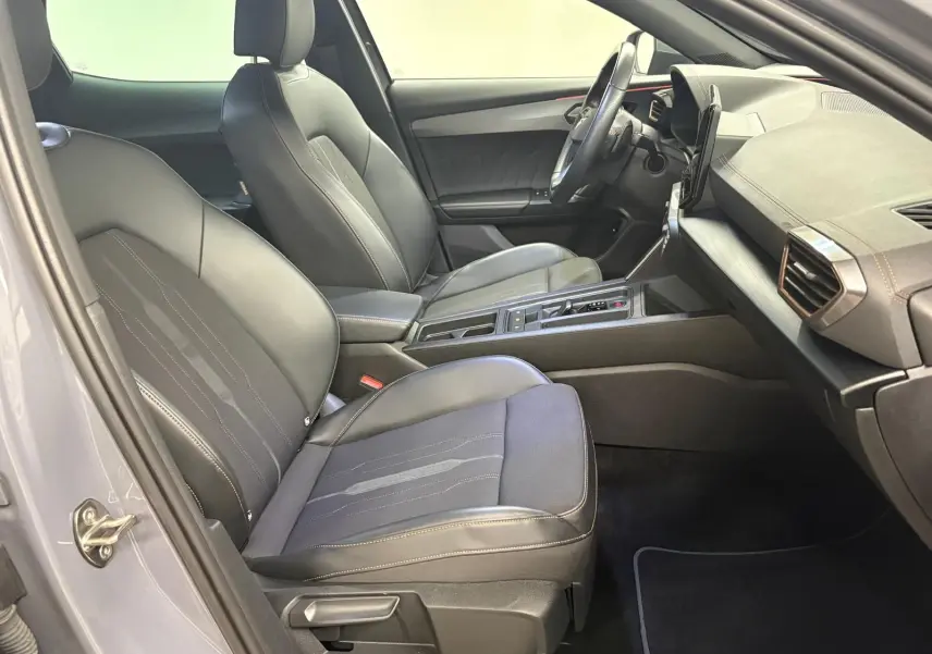 Vue intérieure côté conducteur du CUPRA Formentor 1.5 TSI 2022, sièges noirs avec surpiqûres contrastantes et tableau de bord moderne.