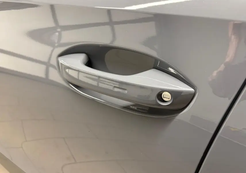 Poignée de porte côté gauche du CUPRA Formentor 1.5 TSI 150 DSG7 en gris Graphène avec serrure visible.