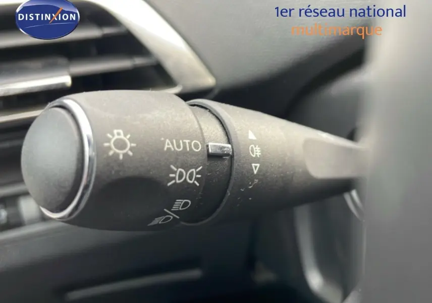 Gros plan sur la commande des feux du Peugeot 3008 hybride rechargeable 2024, intérieur noir avec détails chromés.