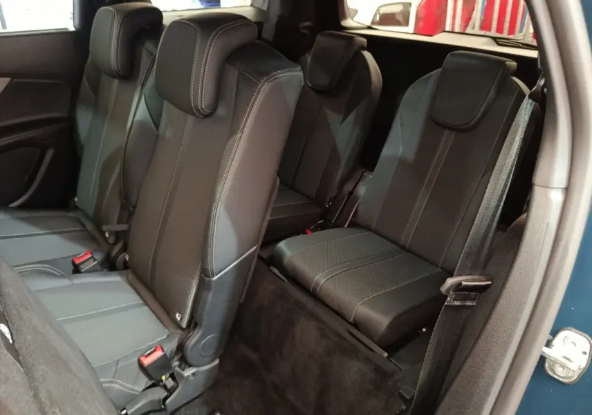 Vue intérieure côté droit montrant les sièges arrière noirs du Peugeot 5008 PureTech 130 GT bleu 2023.