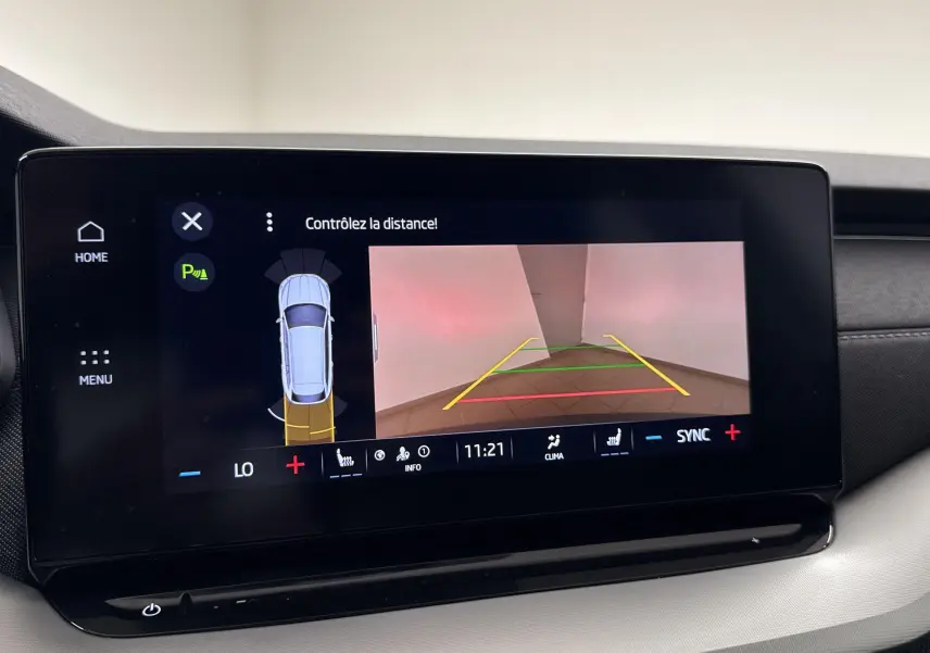 Écran central de la Skoda Octavia Combi 2023 affichant la caméra de recul et l'aide au stationnement en intérieur.