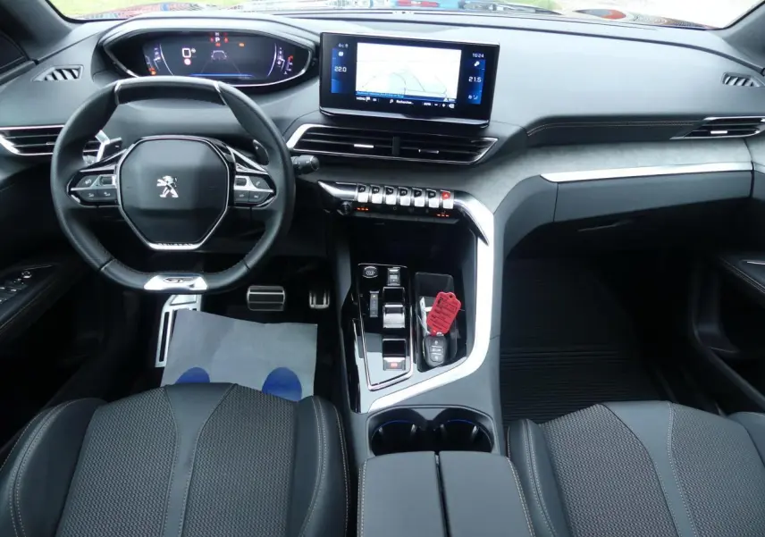 Vue intérieure avant du Peugeot 5008 GT 2023 avec tableau de bord numérique, écran tactile et volant compact cuir noir.