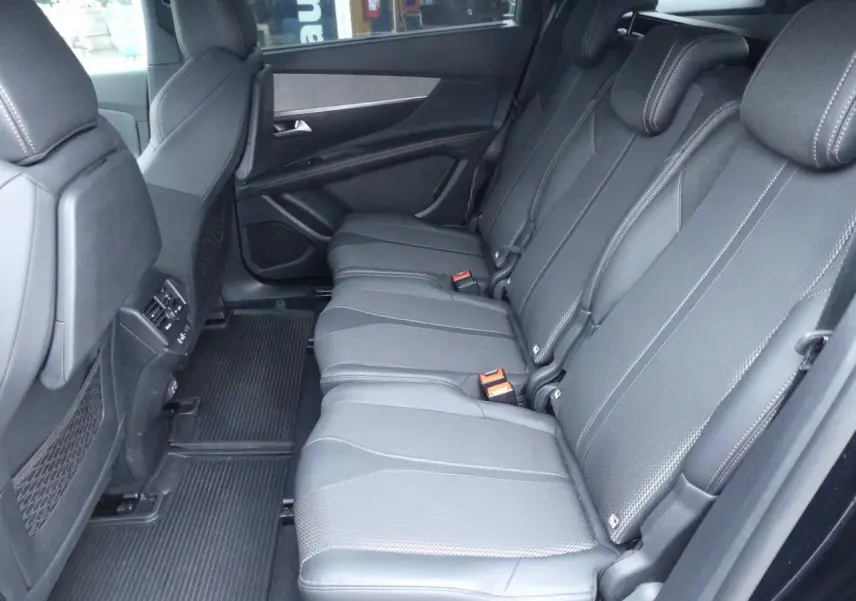 Vue latérale des trois sièges arrière indépendants en cuir noir du Peugeot 5008 GT 2023, avec accoudoirs et ceintures visibles.