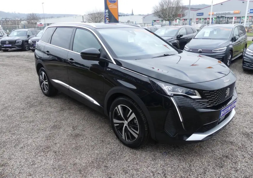 Peugeot 5008 GT noir métallisé vue 3/4 avant droit, avec jantes alliage bi-ton et calandre chromée distinctive.