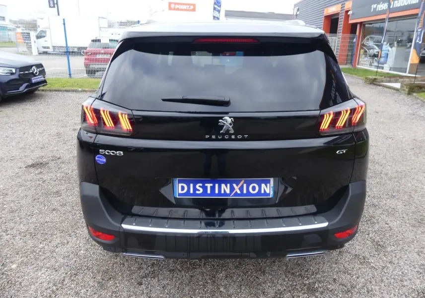 Vue arrière du Peugeot 5008 GT noir métallisé avec feux arrière LED 3D et double sortie d'échappement chromée.