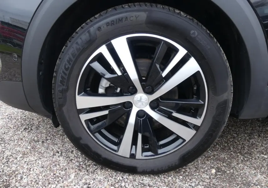 Gros plan sur la jante alliage 18 pouces bi-ton noir et argent du PEUGEOT 5008 noir métallisé, roue avant droite.