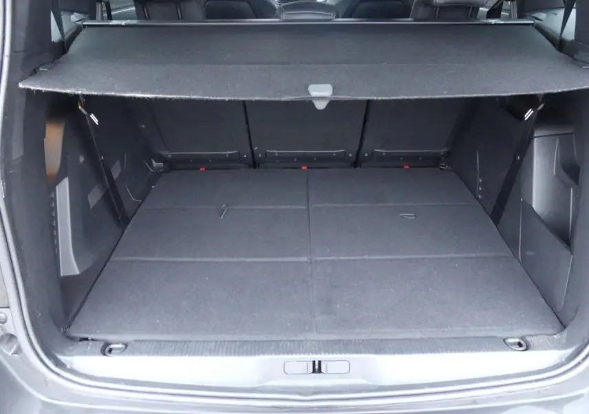 Coffre ouvert du Peugeot 5008 GT noir métallisé, montrant l'espace de chargement avec cache-bagages déployé.