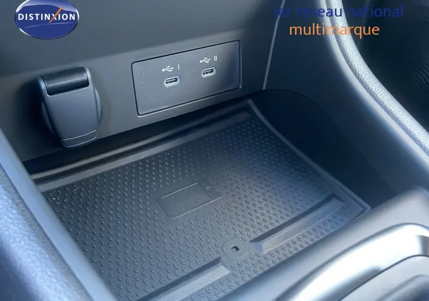 Gros plan sur la console centrale du Renault Captur E-Tech avec deux ports USB-C et un espace de rangement noir.