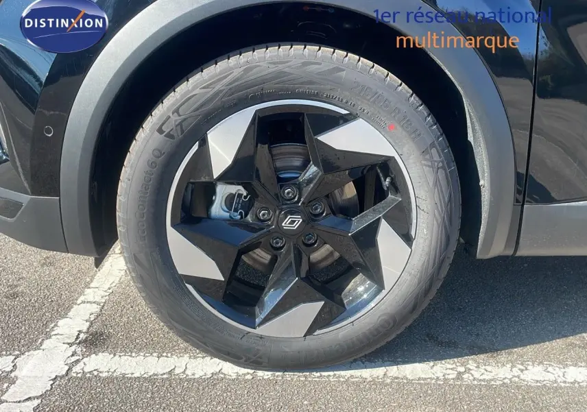 Gros plan sur la roue avant droite du Renault Captur noir étoile métal avec jante noire et argentée design étoile.