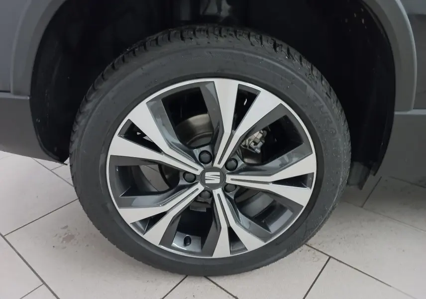 Gros plan sur la jante alliage 18'' usinée du SEAT Ateca noir Magic Nacré, mettant en valeur son design moderne.