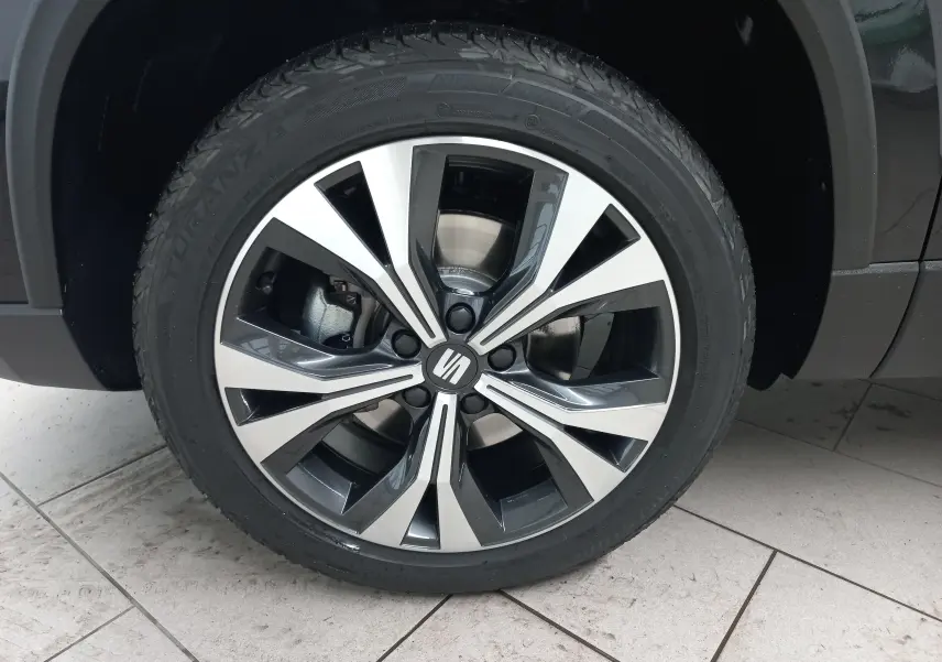 Gros plan sur la jante alliage 18'' usinée du SEAT Ateca noir Magic Nacré, mettant en valeur son design moderne.