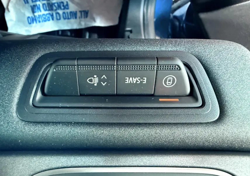 Gros plan sur les boutons de réglage d'éclairage et mode E-SAVE du tableau de bord du Renault Captur E-Tech Hybrid 2025.