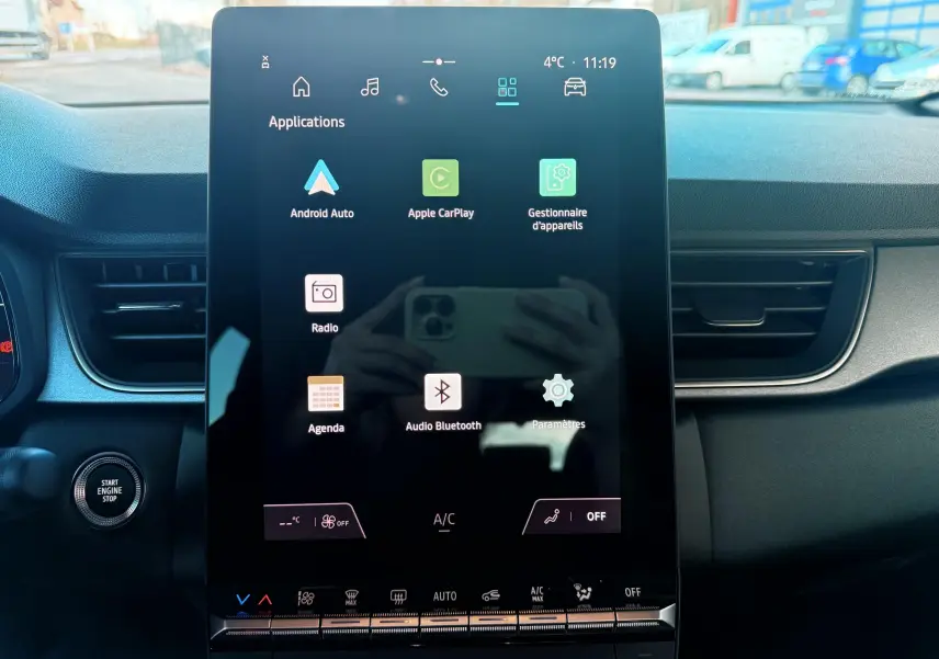 Écran tactile central du tableau de bord du Renault Captur E-Tech 2025, avec commandes climatisation et bouton start visible.