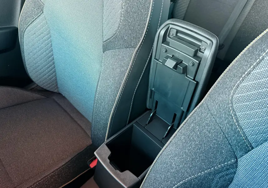 Gros plan sur l'accoudoir central ouvert entre les sièges avant du Renault Captur E-Tech hybride 2025.