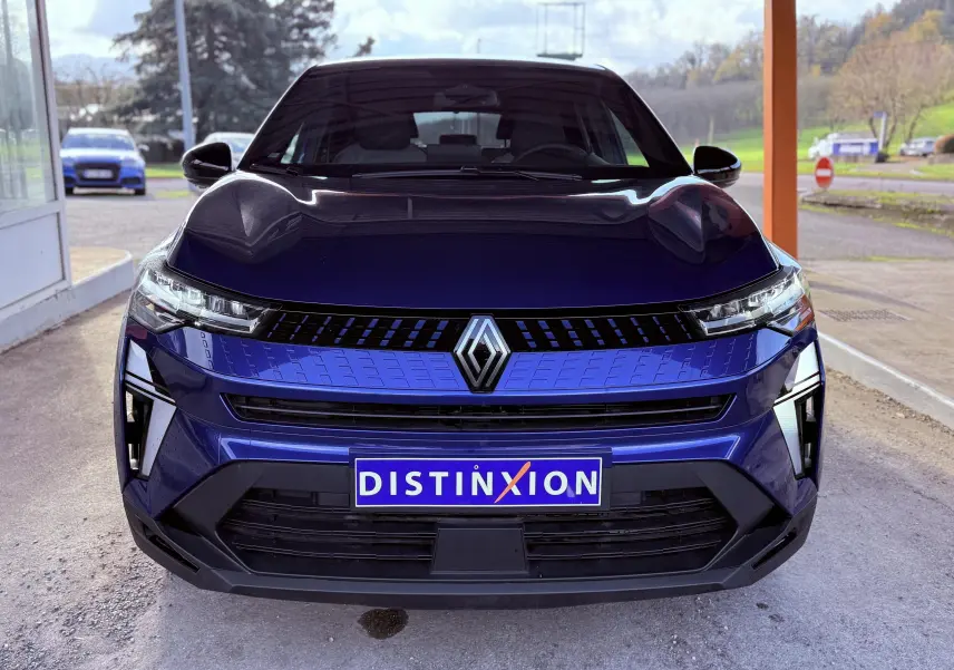 Vue frontale du Renault Captur E-Tech hybride 2025 en bleu Iron Metal avec toit noir et calandre moderne.